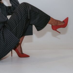 Stylish woman's legs in a pinstripe suit and red heels. Modern fashion statement.